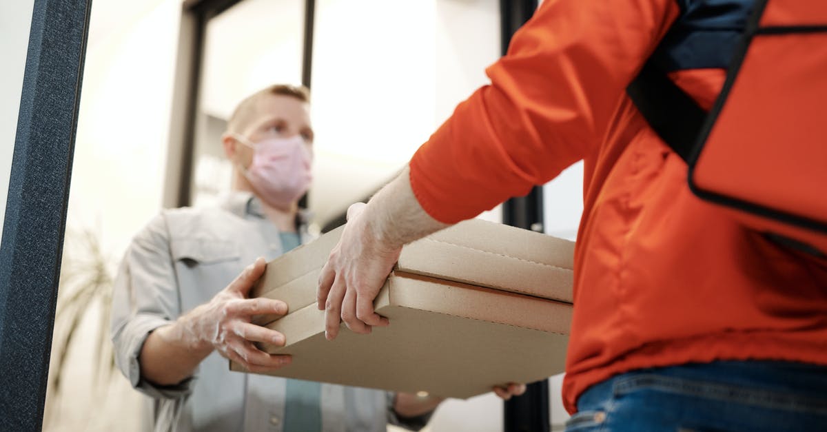 Extension of stay at USA due to COVID-19 lockdown - Man Wearing a Face Mask Receiving a Pizza Delivery