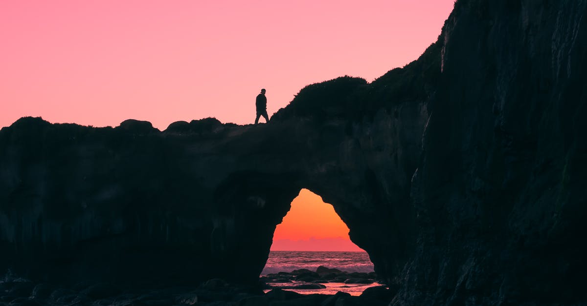 Extra baggage costs - Dragon Airlines / Cathay Pacific - Silhouette of Man on Rock Walking during Nightime