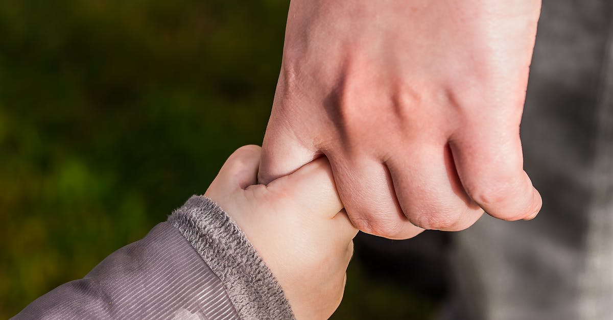 Family 2 adults and 3 children visiting Yellowstone National Park - Child Holding Hand of Another Person