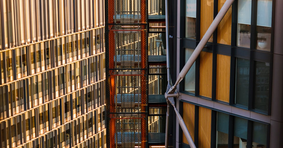 Fastest public elevator in the world - Contemporary multistage houses with beams and creative design located between modern elevator with black grid on sunny street of city