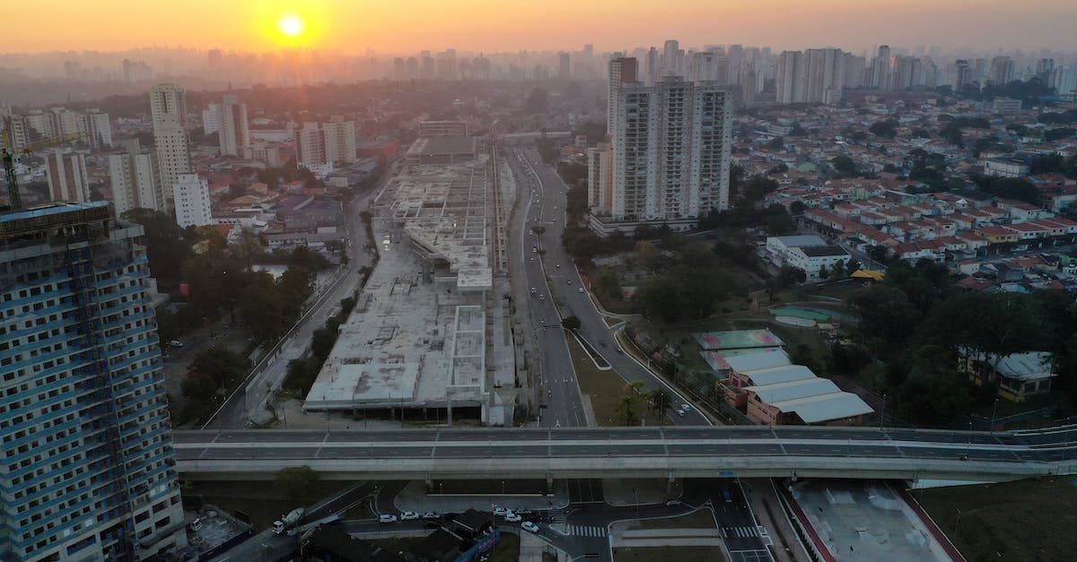Fastest way to get from Suvarnabhumi Airport to down town Bangkok in the early morning - Aerial view of modern city with buildings and empty roads at colorful sunrise