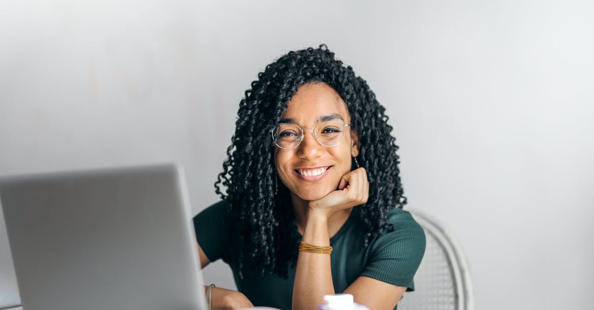 FBI digital fingerprints at USPS? - Happy ethnic woman sitting at table with laptop