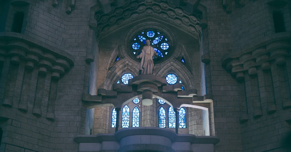 Ferries from Iceland to Portugal or Spain - From below of Sagrada Familia basilica in Barcelona with stained glass windows and sculpture near uneven walls