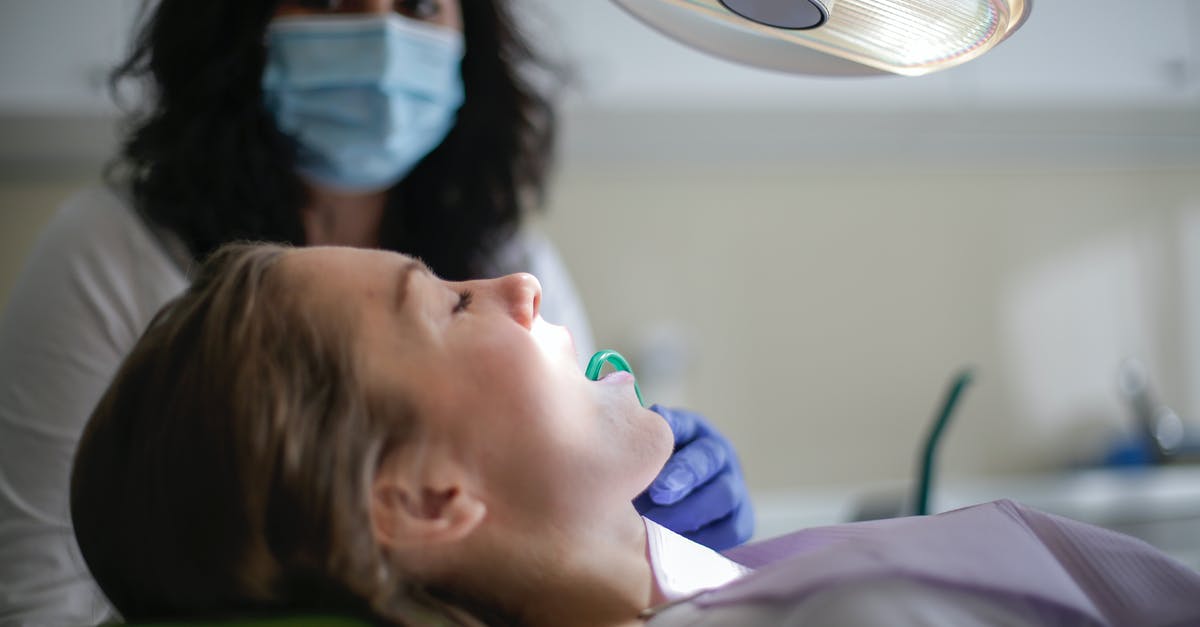 Finding job on Visit visa [closed] - Dental assistant holding saliva ejector in mouth of patient