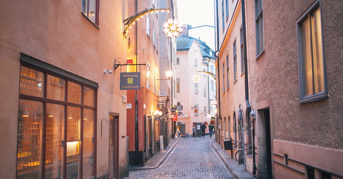 Finding public shower in Europe - Narrow pedestrian street between old residential buildings at twilight