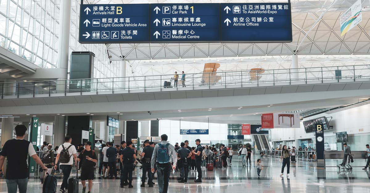 Finding the "Airport Express Shuttle Bus" at Hong Kong station? - People Walking on a Building