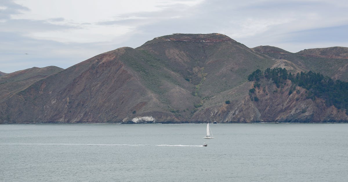 Firearm carried aboard an ocean going sailboat - White Sailboat on Sea Near Green Mountain