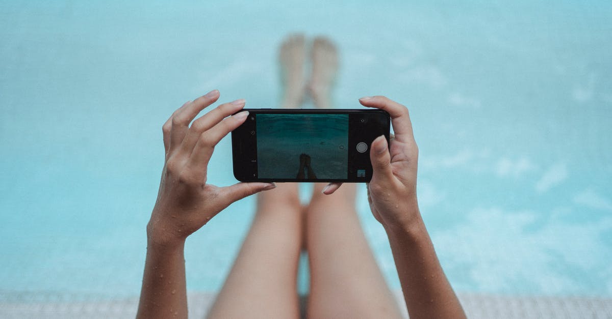 First leg of connection delayed. Can I claim compensation? - High angle crop anonymous female with fit body relaxing on poolside and taking picture of legs