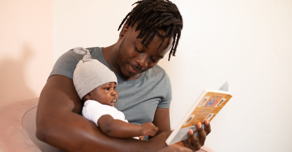 First time traveler: how do I book flights? - Man in Gray Shirt Holding Baby in White Onesie