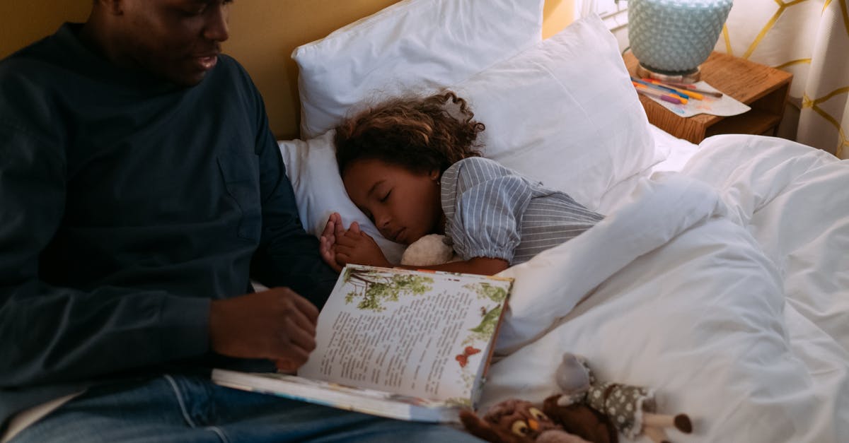 First time traveler: how do I book flights? - Father Reading Bedtime Story For His Daughter while Lying Down on the Bed