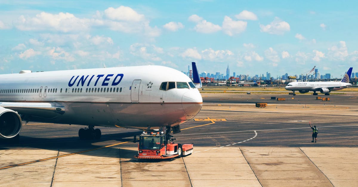 Flight Connection in Salt Lake City airport - White Airplane Near Man in Green Vest