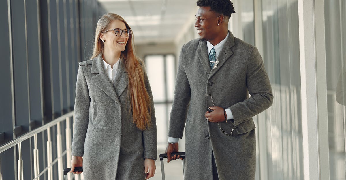 Flight diversion + visa issues - Stylish colleagues walking along airbridge in airport