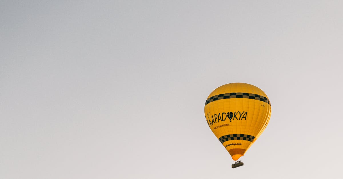 flight time is not clear - From below of bright yellow hot air balloon flying in cloudless blue sky in Cappadocia in daytime