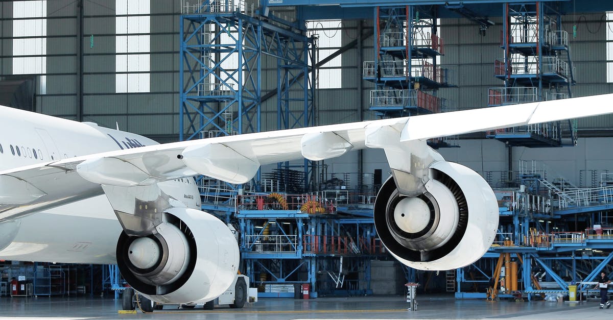 Flight to a different airport from the one booked - Low angle of engines and wing of modern aircraft in docking station on sunny day