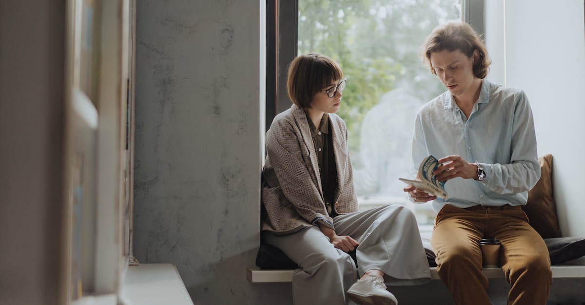 Flight/booking code explanation - Man and Woman Sitting on Chair Beside Window