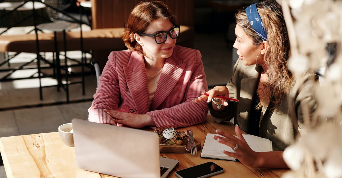 Flights with two different airlines, how does online check-in work? - Woman in Red Blazer Sitting by the Table Having a Meeting