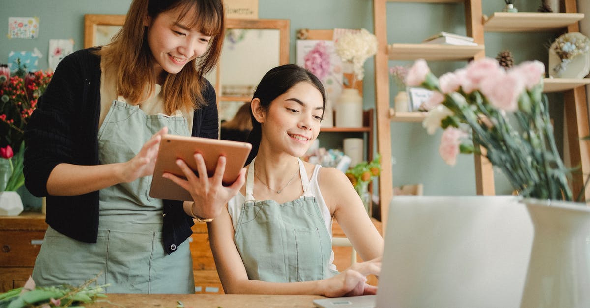 Flower shop in O'Hare? - Happy multiracial women working on gadgets in floral store