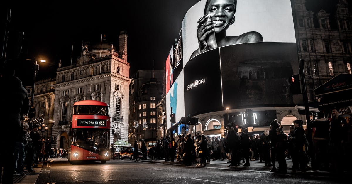 Fly into London (LTN) at late night - Low Angle Photo of People Waiting for the Red Bus to Pass