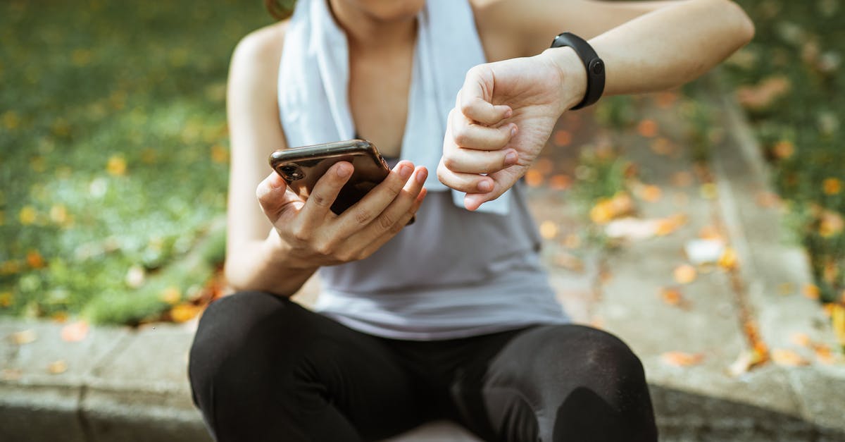 Flying for the first time tomorrow, is a physical boarding pass required or is the app enough? - Anonymous female in sportswear using smartphone and smart watch after exercising on sports ground