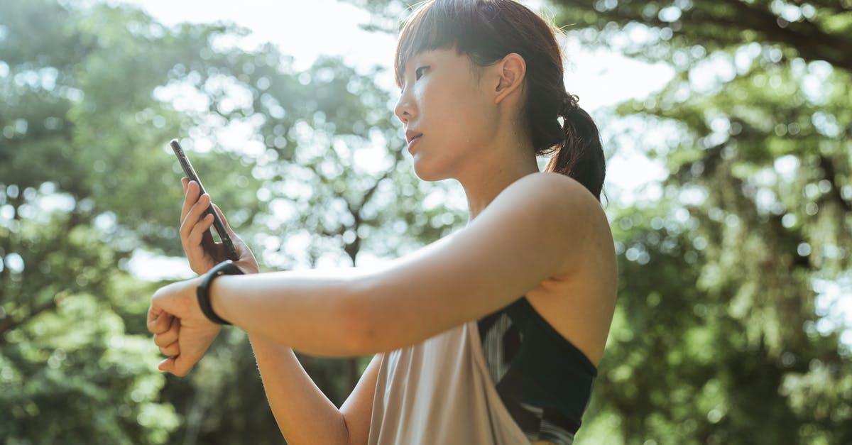 Flying for the first time tomorrow, is a physical boarding pass required or is the app enough? - Young Asian woman using devices for fitness in park