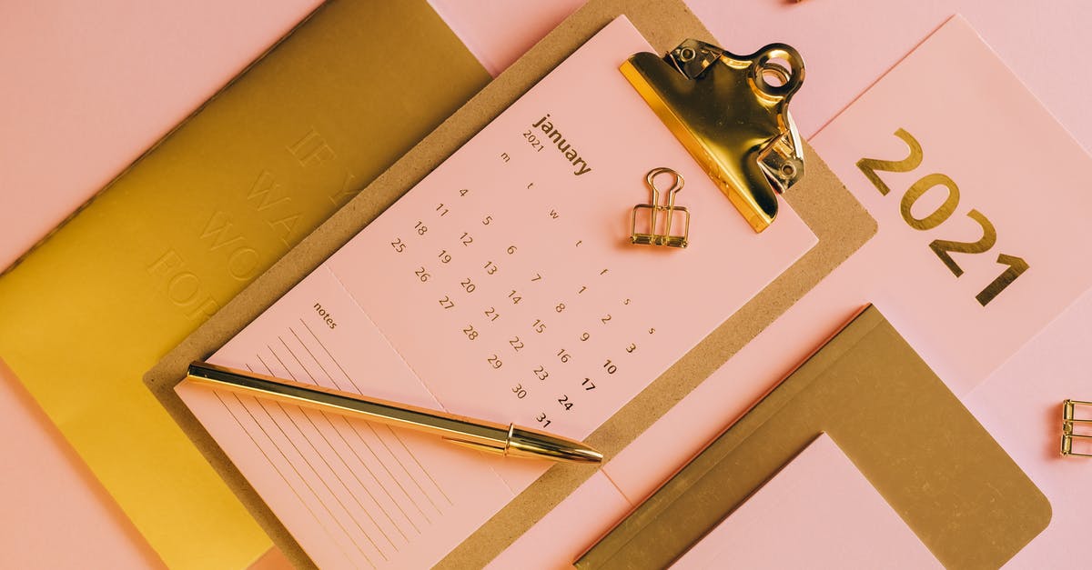 Flying from Canada with art supplies - From above stylish workplace consisting of clipboard with calendar and golden notebook on pink background