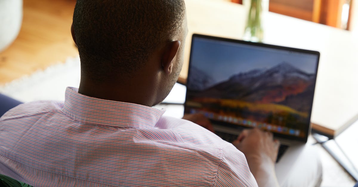 Flying with a desktop computer (as checked luggage) - Back view of anonymous unrecognizable African American male in shirt typing on netbook on blurred background of room