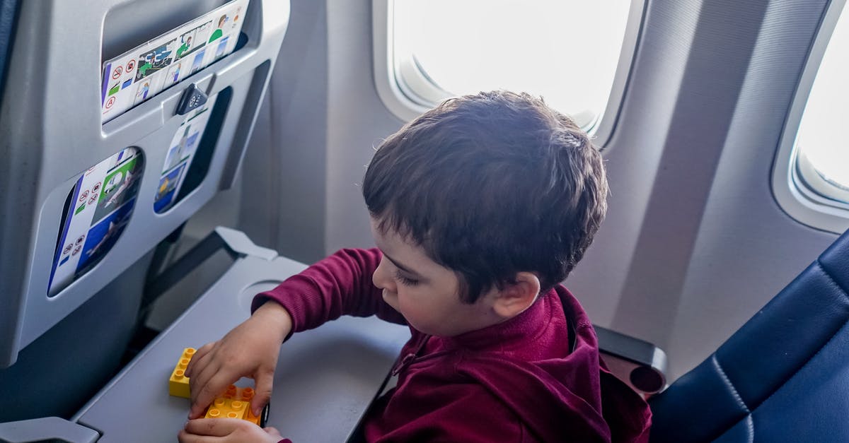 Flying with a lap child on a code shared flight - Boy playing with toy on plane