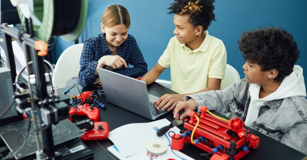 Flying with a Prusa Mendel 3d printer - Cheerful group of teenagers using laptop