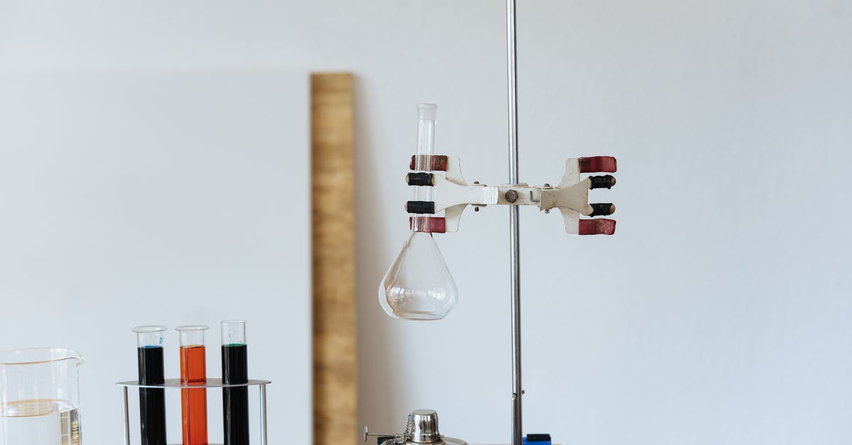 Flying with fragile items on KLM - Chemical test with empty flask mounted on ring stand while burner under flask and tubes filled with reagents in modern lab