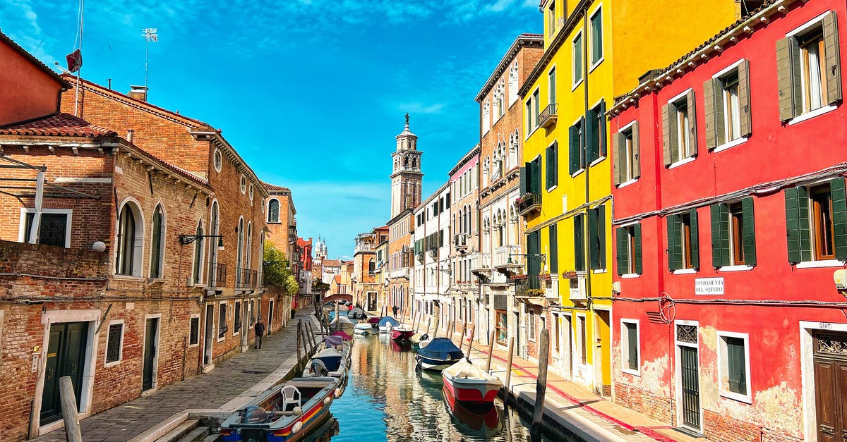 Following in the Footsteps of Hemingway in Italy - Boat on River Between Buildings