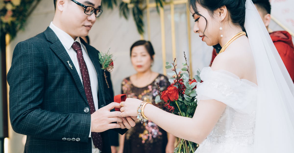 Foreign exchange in Cuba - how to prepare with cash? - Side view of crop ethnic bride with makeup in dress with bridal bouquet and groom in suit with eyeglasses preparing rings during marriage ceremony in decorated hall behind parent