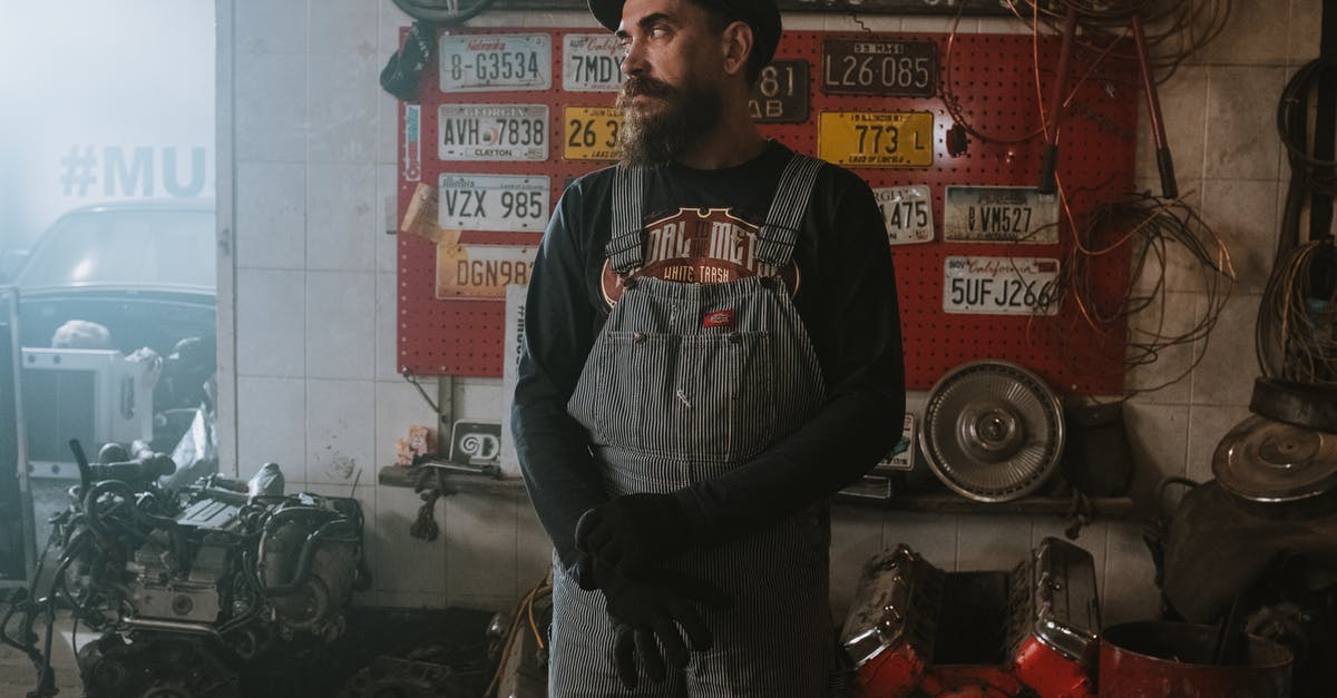 Foreign license plates in Macedonia - Man in Black and White Crew Neck T-shirt Standing Near Red and Black Wall