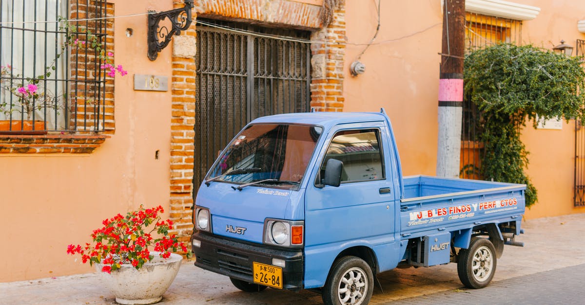 Foreign license plates in Macedonia - Old mini truck near urban roadway and house facade