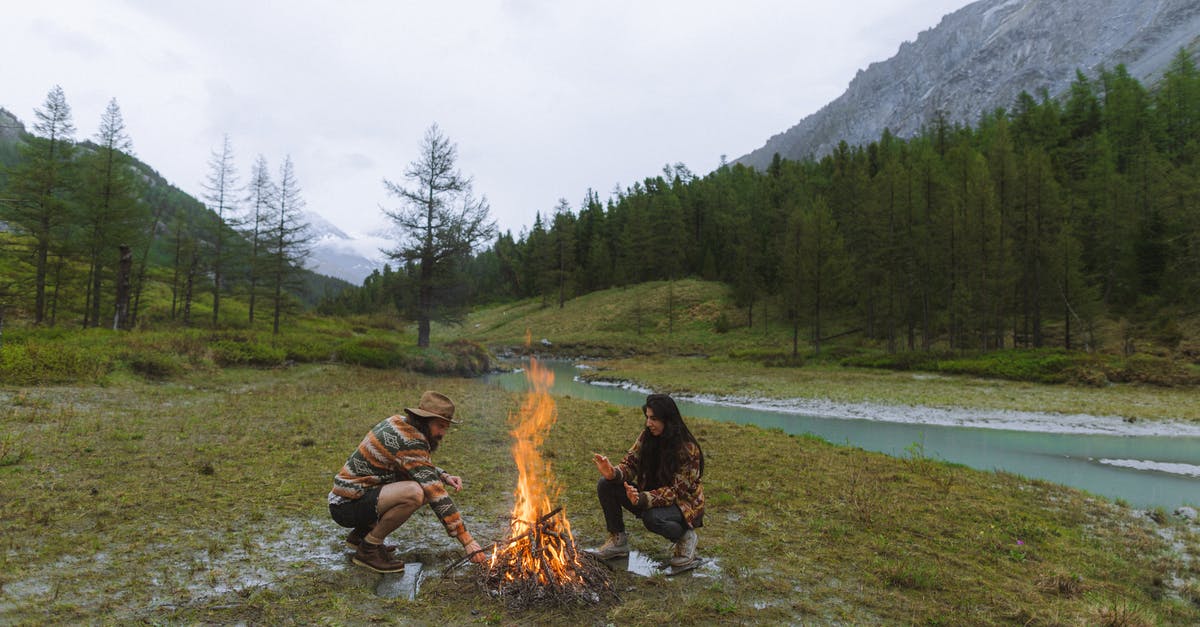 Former Gulag camps in Russia - Man and Woman Sitting on Grass Near Bonfire