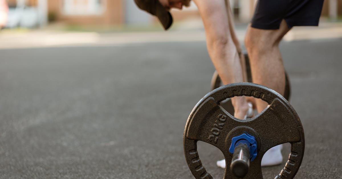 Forwarding a Canadian number abroad? - Crop sportsman preparing to lift barbell on pavement