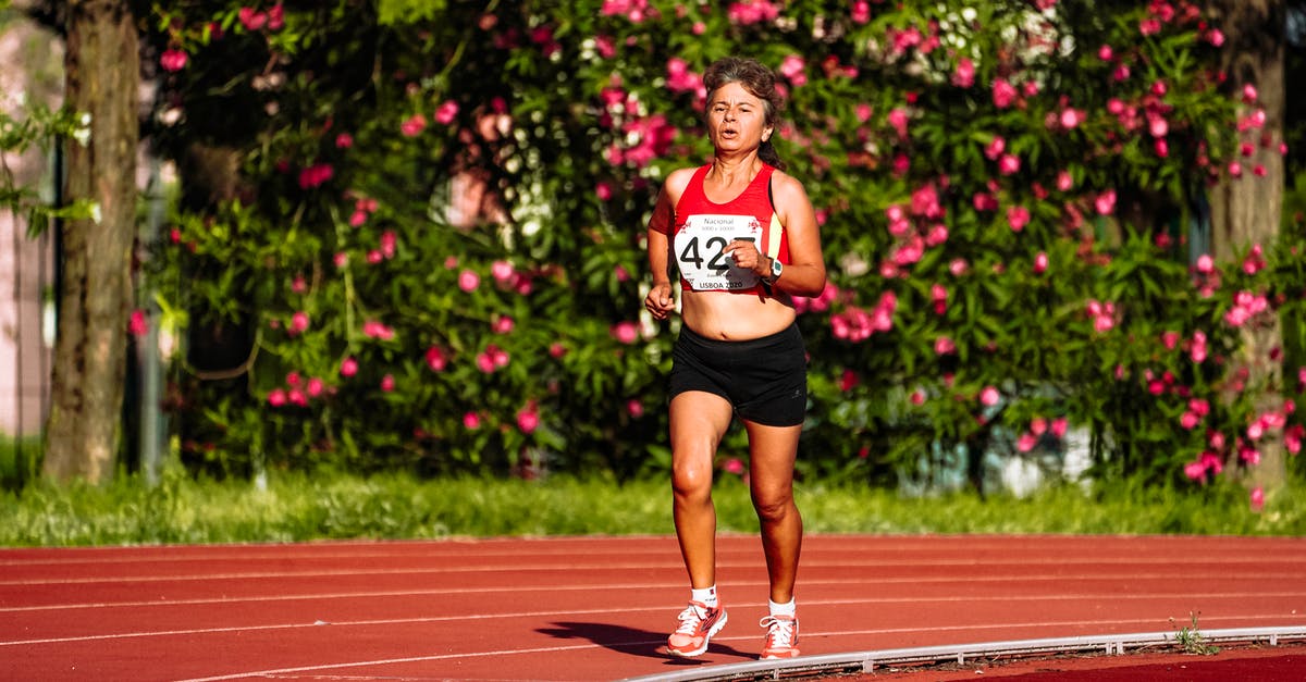 Forwarding a Canadian number abroad? - Middle aged female athlete in sportswear running during track and field competition while looking forward