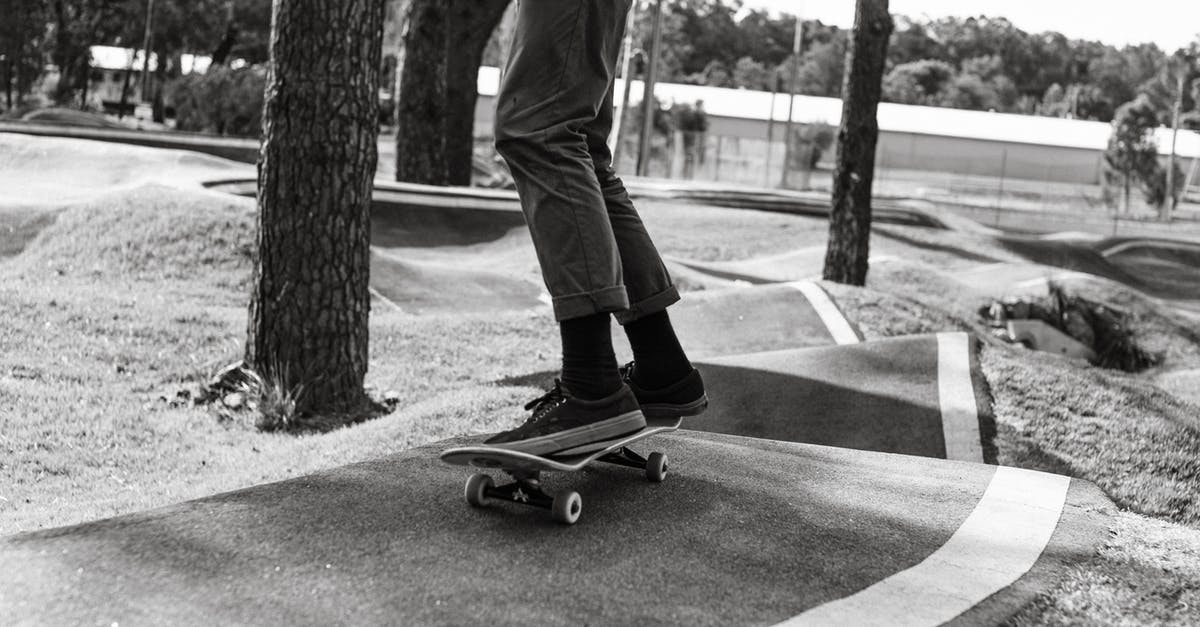 Free park and ride between Siegburg and airport DUS? - Crop skater riding skateboard on asphalt ramp in park