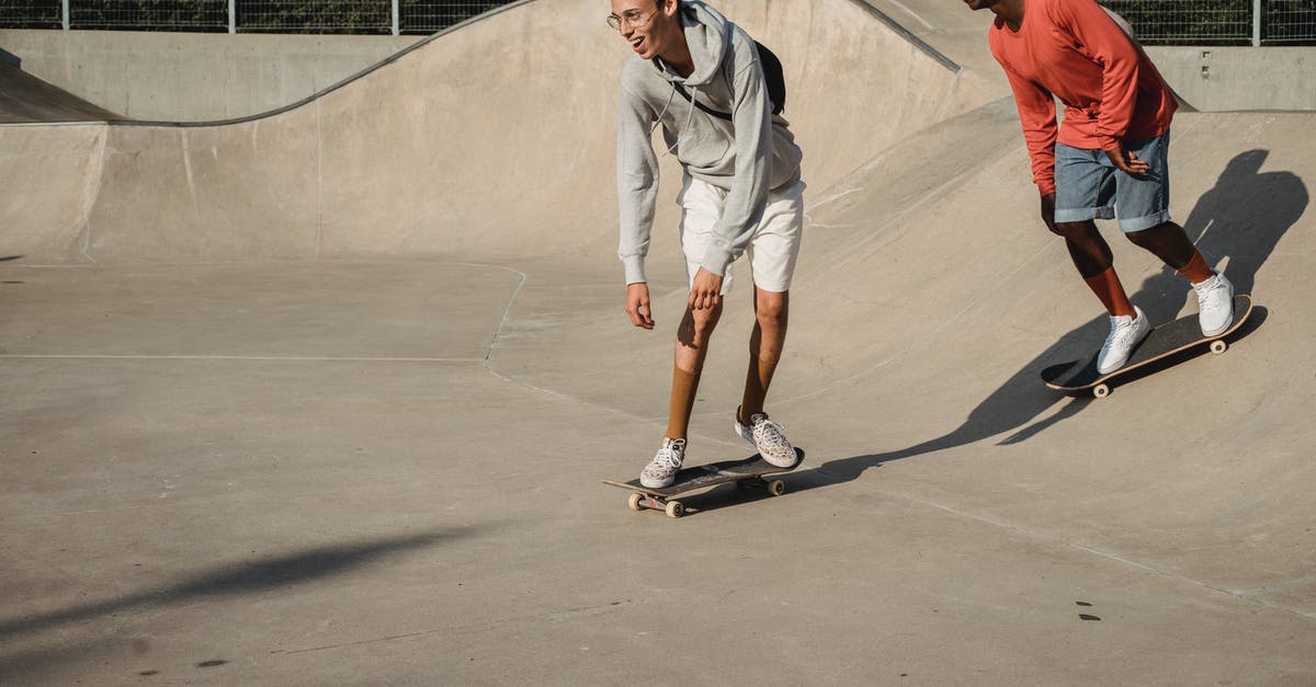 Free park and ride between Siegburg and airport DUS? - Happy young guy and African American friend getting ready to perform trick on skateboard on asphalt ramp in skate park on sunny weather