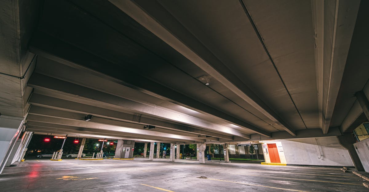 Free street parking options for unlimited time in Bratislava? - Entrance to underground parking with empty spaces under concrete roof at night time