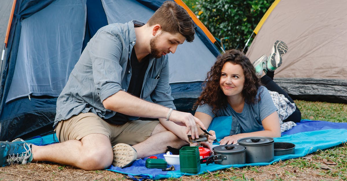 Free tent camping location close to Adelaide? - Positive young couple using portable camping gas stove while resting of plaid near tent during romantic trip in nature