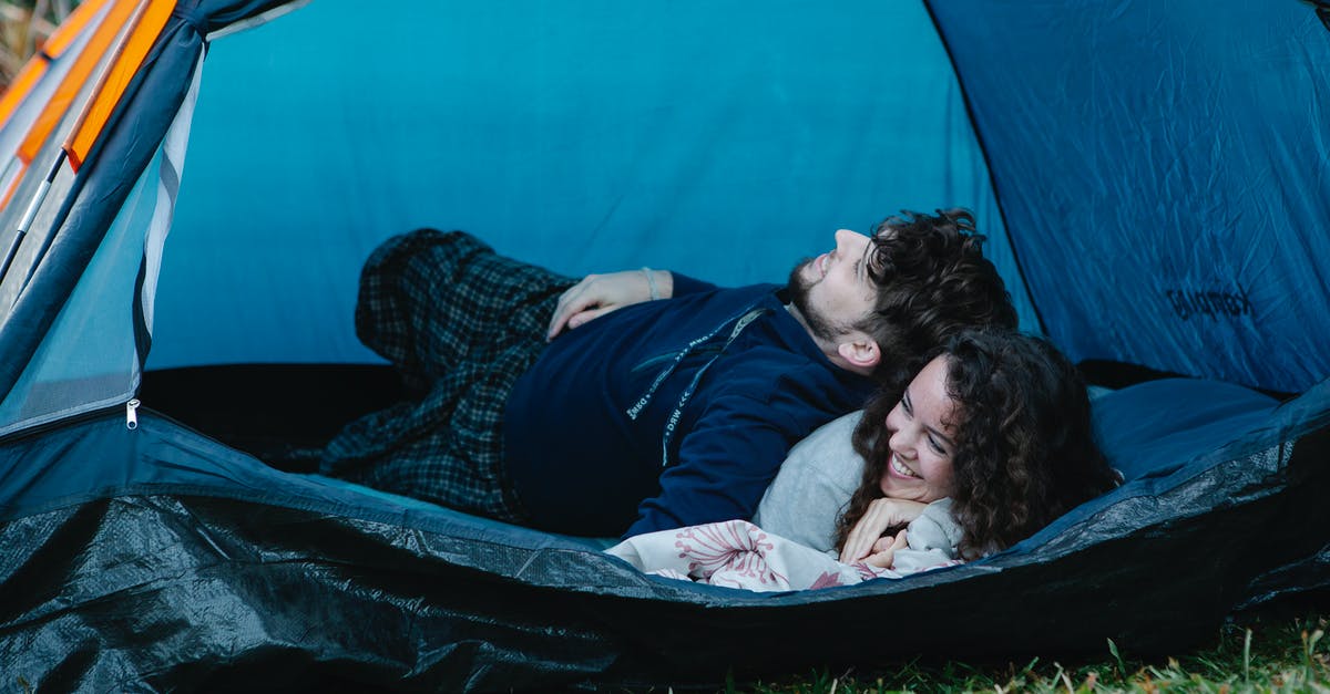 Free tent camping location close to Adelaide? - Young happy couple lying together in camping tent and enjoying weekend in countryside