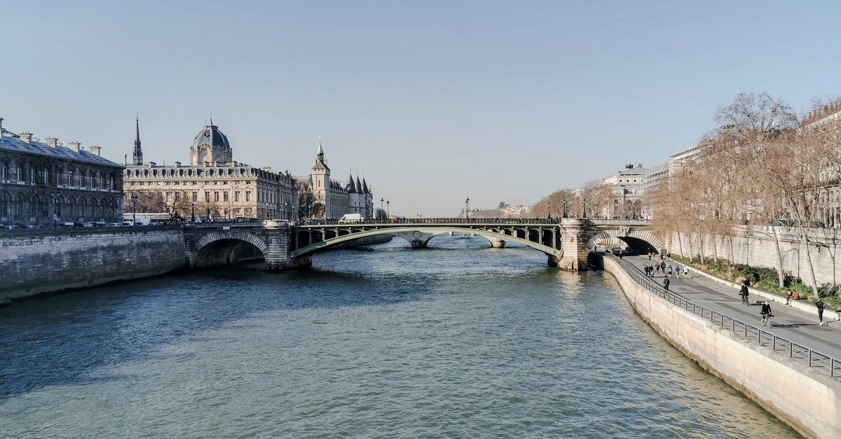 French bookshops in Paris - Aged bridge above rippled river between old stone house exteriors under light sky in France