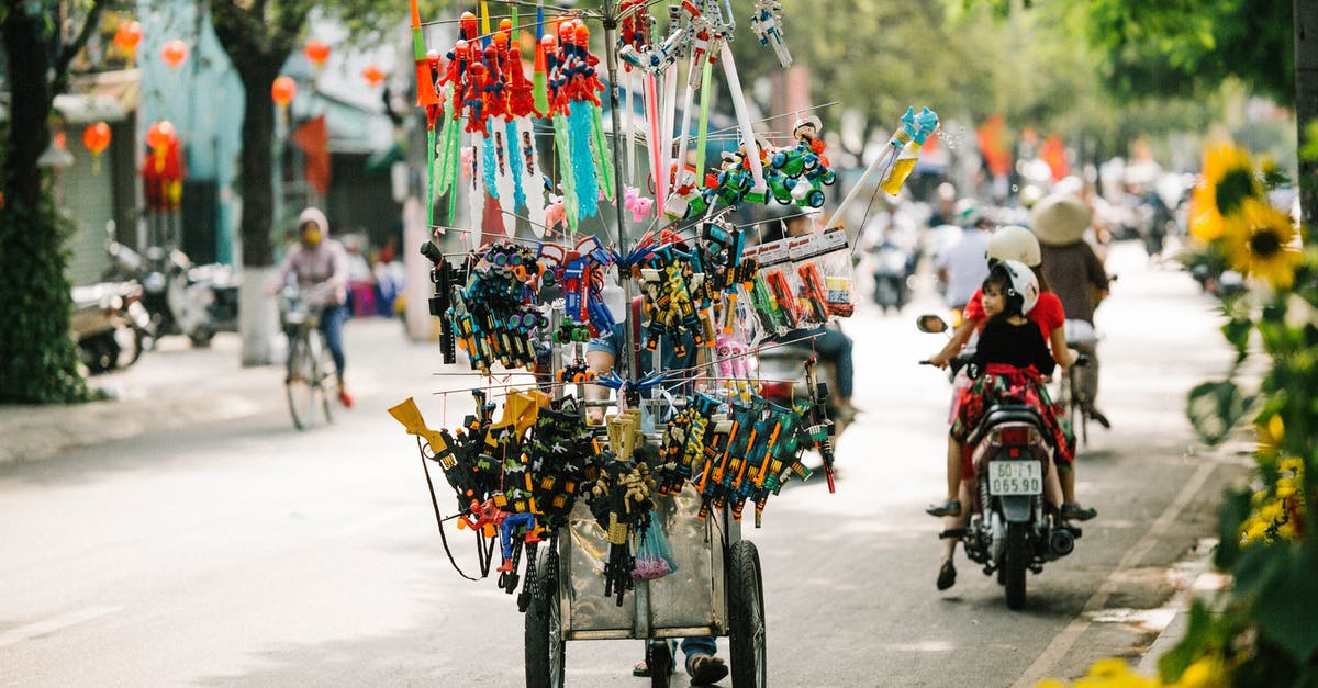 French visa processing location and public holidays - Stall of souvenirs and toys on green wide street