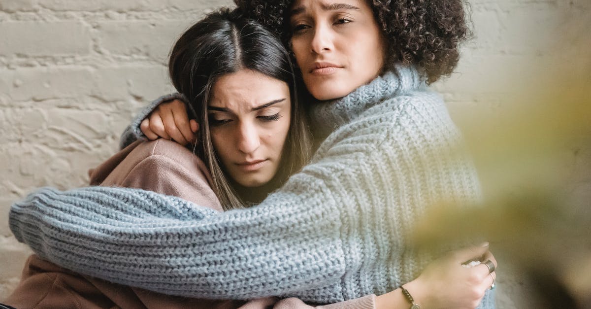 Friend needs help in Turkey - Depressed diverse women hugging near wall