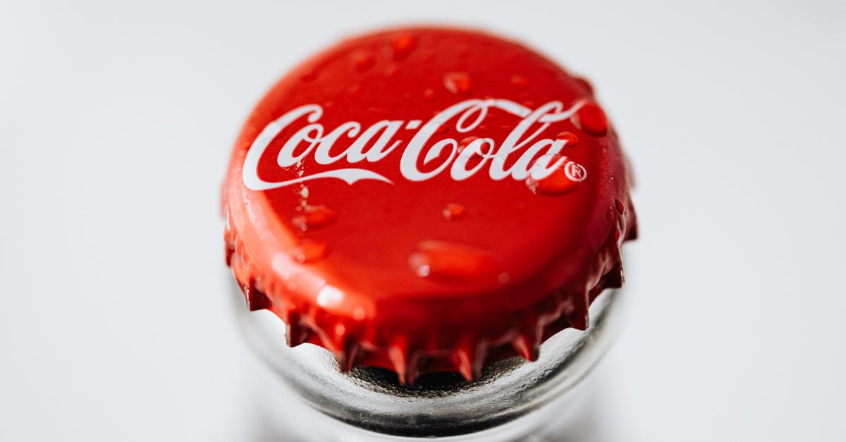 From J1 TO ESTA the same year - Closeup of red metal bottle cap placed on glass bottle with water droplets on white background