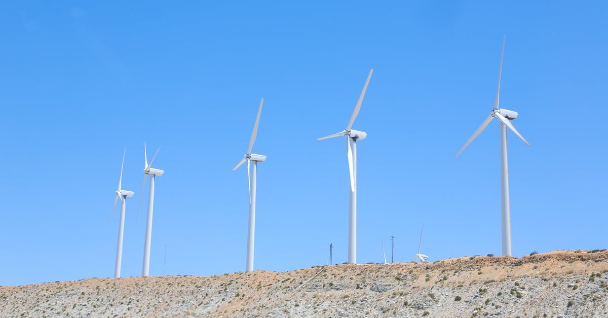 From London to Rome by sea, land and air [closed] - Vibrant blue cloudless sky over tall white wind turbines on slope in empty field in daytime