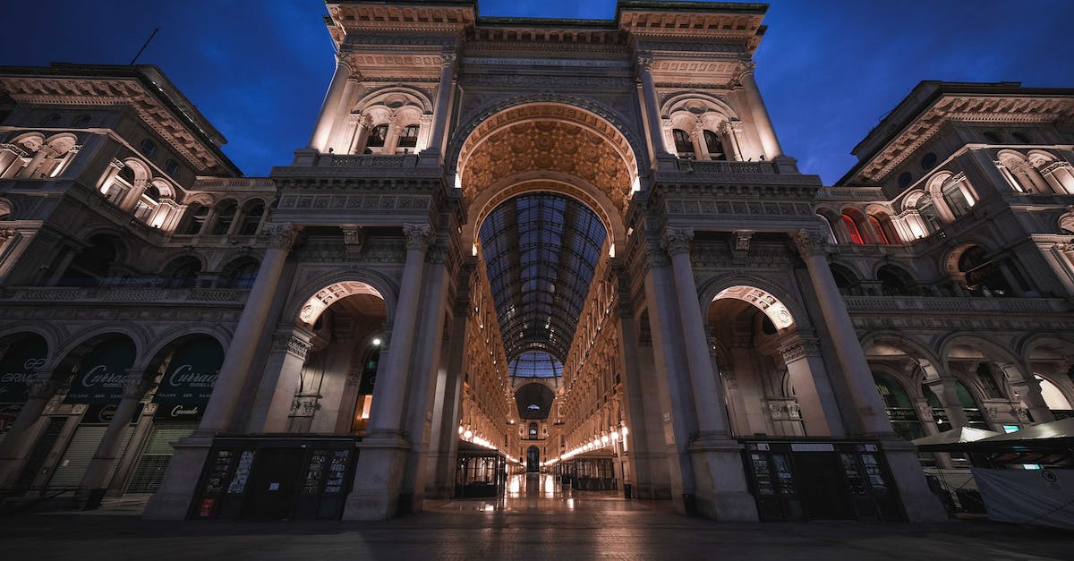 From whom can I buy travel insurance if I don't "live" anywhere? - From below of ancient famous Galleria Vittorio Emanuele II shopping mall with arched passage and ornamental ceiling located on square in Milan against night sky