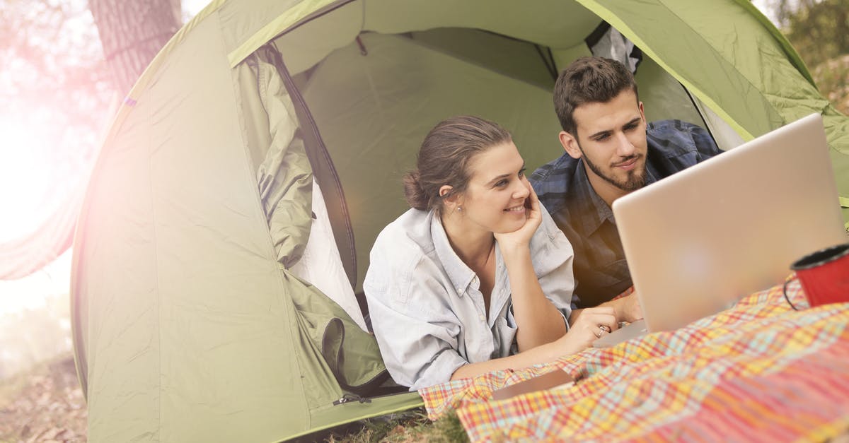 Fuerteventura surfing and quiet romantic accommodation [closed] - Happy couple using laptop in tent