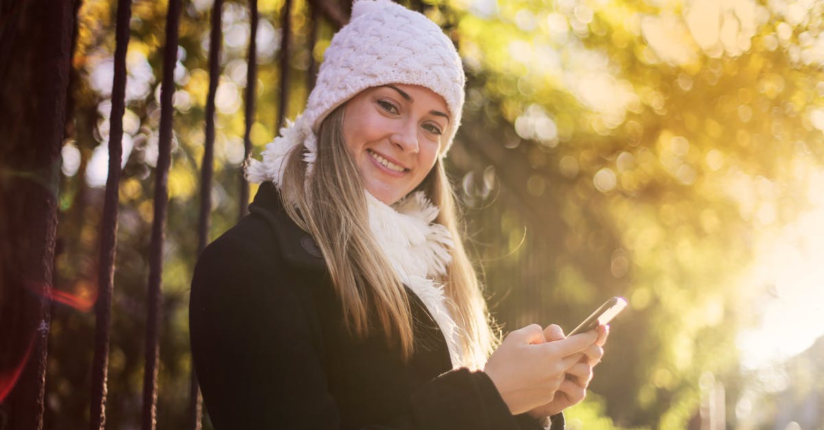 Gate to gate electronic device usage on AmericanConnection/Chautauqua Airlines? - Smiling woman chatting on smartphone in park