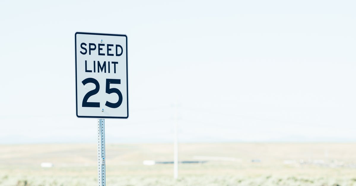 German autobahn speed limit - White sign on roadside with speed limit against empty green field at daytime